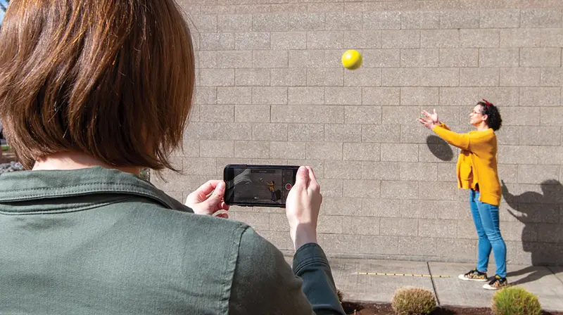 Estudiante grabando con un teléfono el lanzamiento de una pelota para analizarlo con Vernier Video Analysis